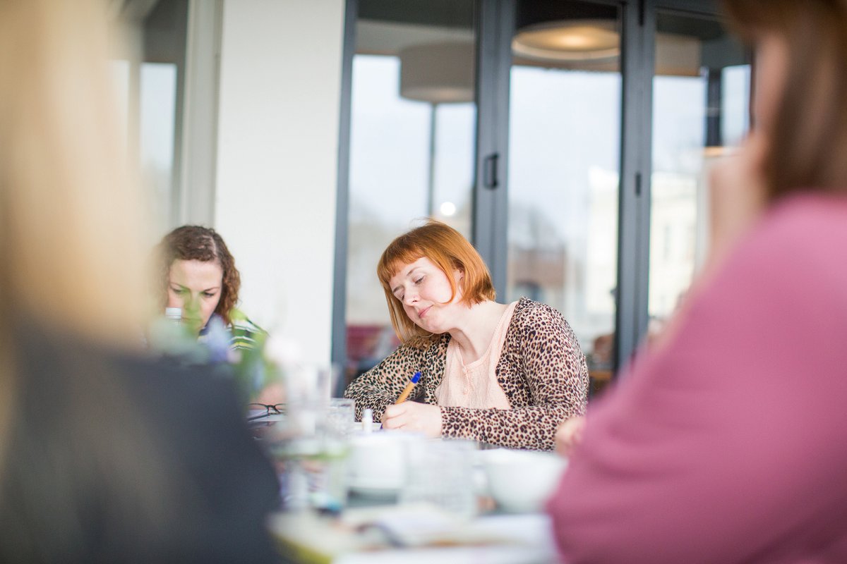 Female business owner taking notes at workshop